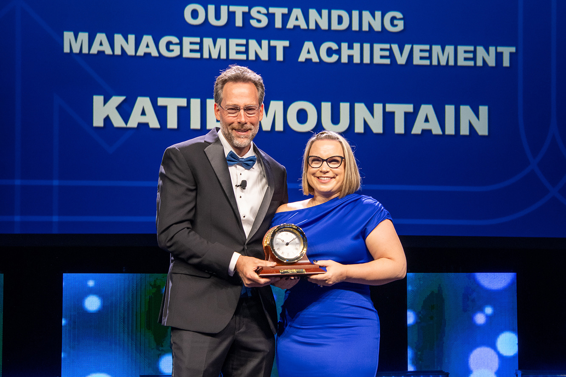 Landstar President and CEO Frank Lonegro (left) presents Vice President of Business Development Katie Mountain (right) with the Landstar Outstanding Management Achievement Award