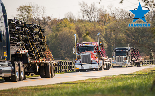 Landstar flatbed trailer hauling automotive materials.